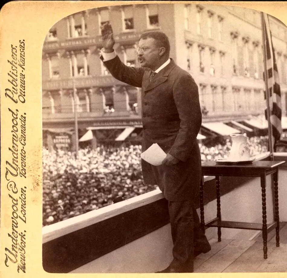 Theodore Roosevelt addressing a crowd from a platform