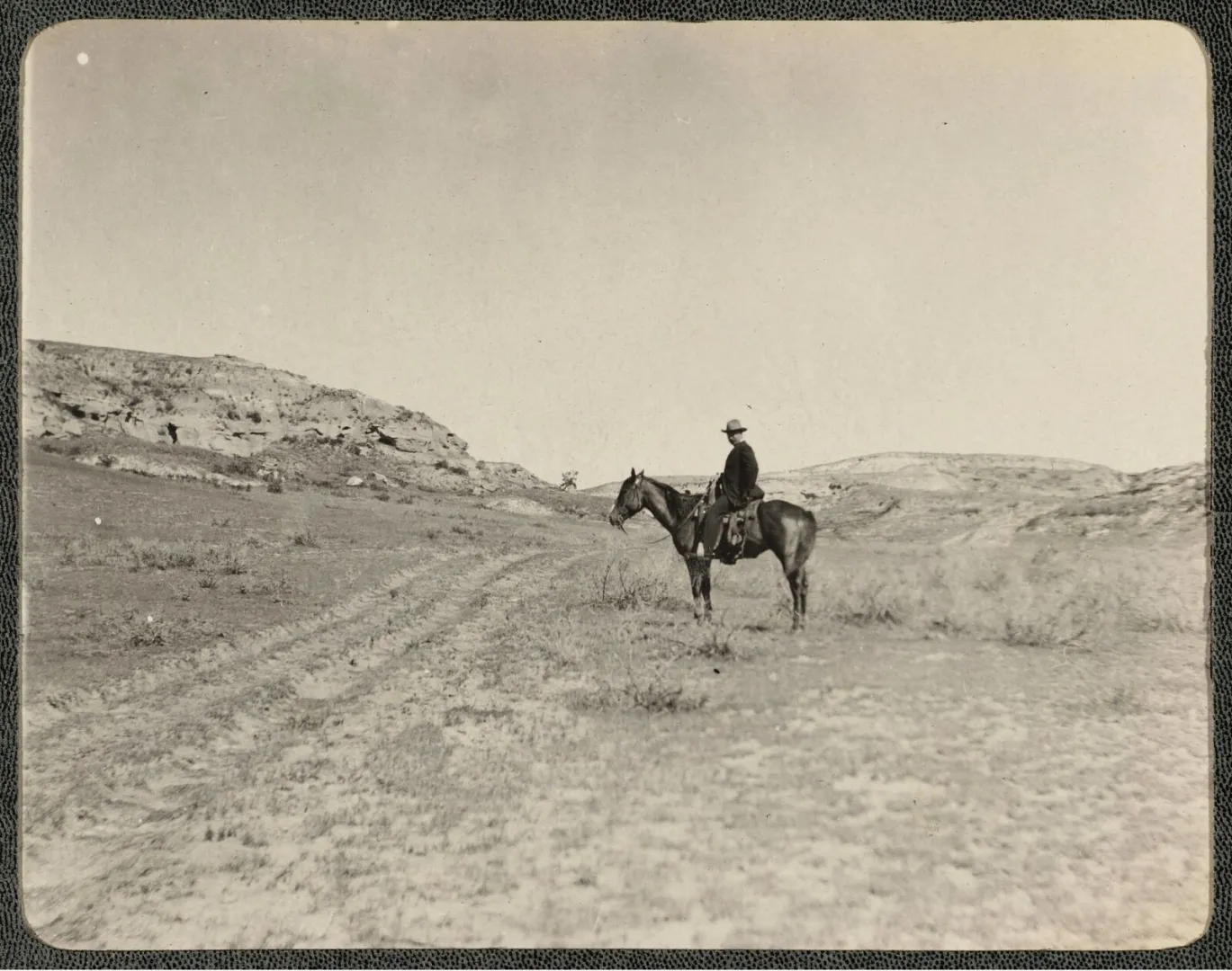 Theodore Roosevelt on horseback riding across the Badlands