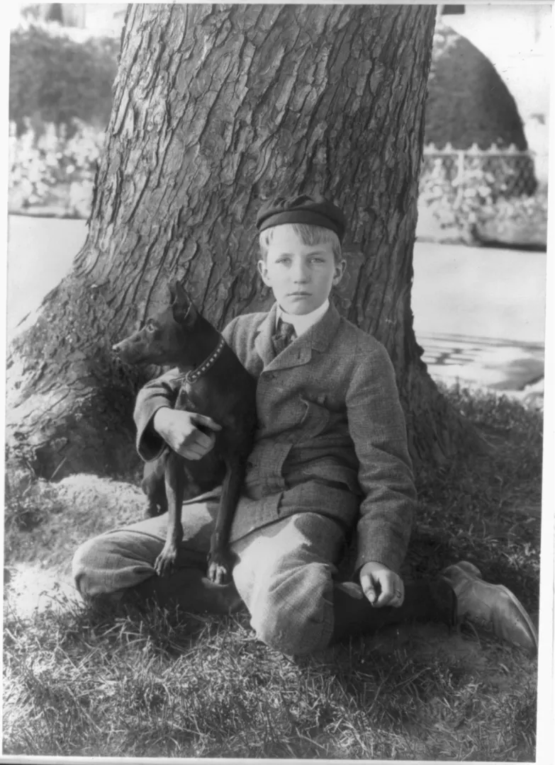 Kermit Roosevelt sitting under a tree with Jack the dog