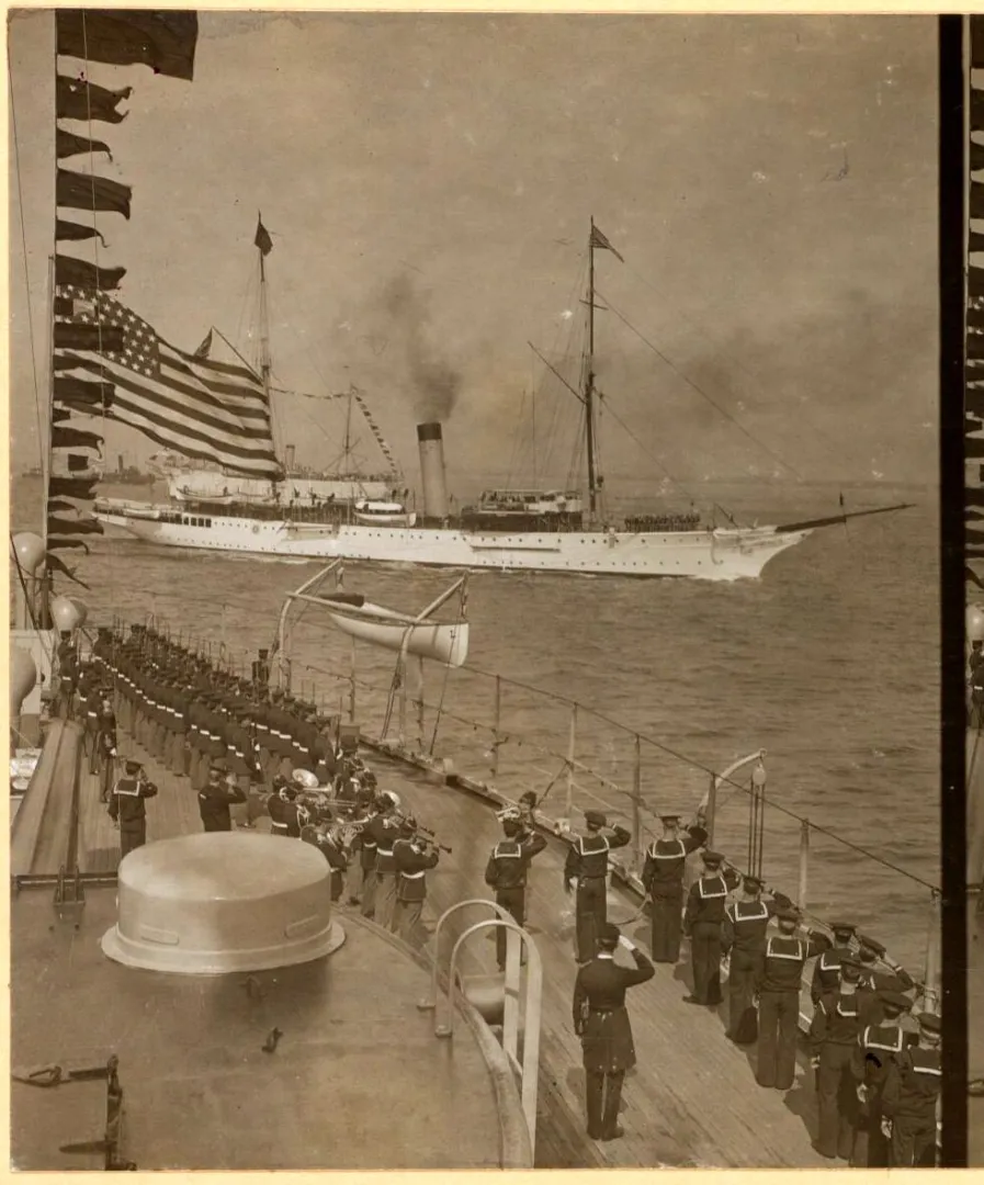 Sailors and a ship's band arrayed on the deck of a battleship