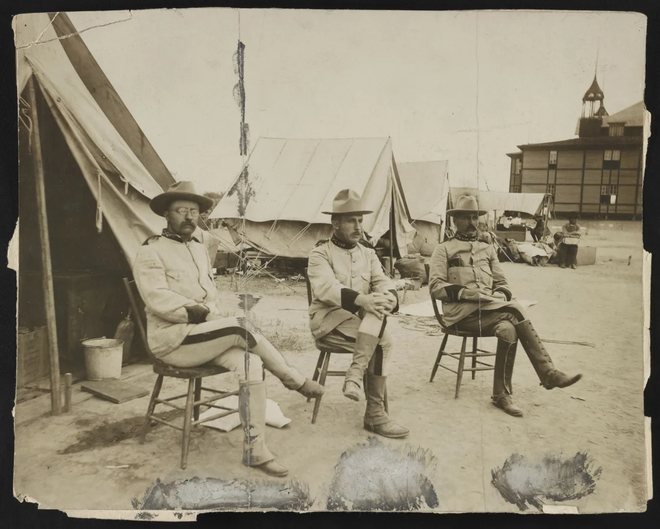 Theodore Roosevelt and Leonard Wood seated at a military camp