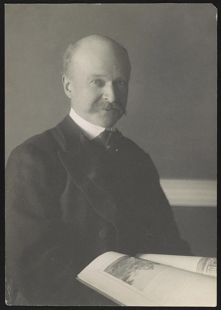 Portrait photograph of architect Charles Follen McKim, a bearded man in a dark suit.