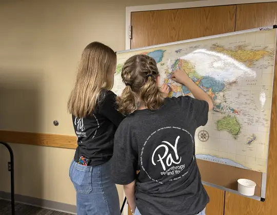 Young people placing pins on a map