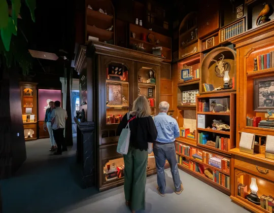 Visitors view artifacts and objects in a richly appointed gallery at the Theodore Roosevelt Presidential Library