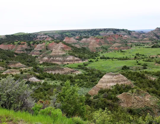 Colorful layered buttes striped with red, tan, and gray sediment at Painted Canyon in the North Dakota Badlands