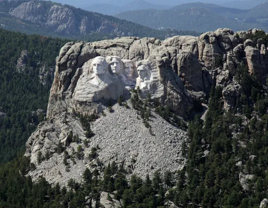 Aerial view of the Mount Rushmore carving in the granite of the Black Hills, surrounded by ponderosa pine
