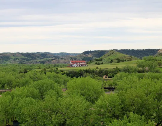 The Chateau de Mores on its bluff above the green Little Missouri River bottomland