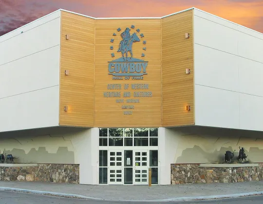 North Dakota Cowboy Hall of Fame building with its gold buckle emblem at sunset