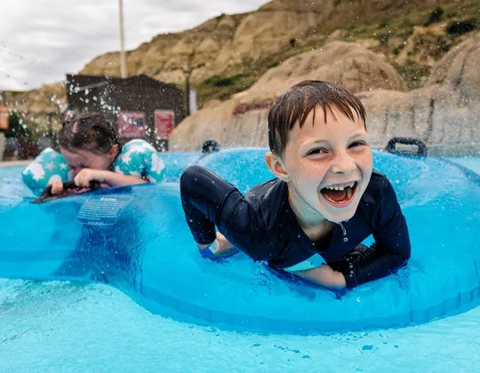 Child laughing on a tube in the pool