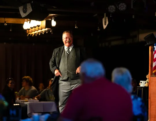 Theodore Roosevelt portrayer performing for a dining audience