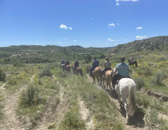 Line of riders on a trail through the Badlands