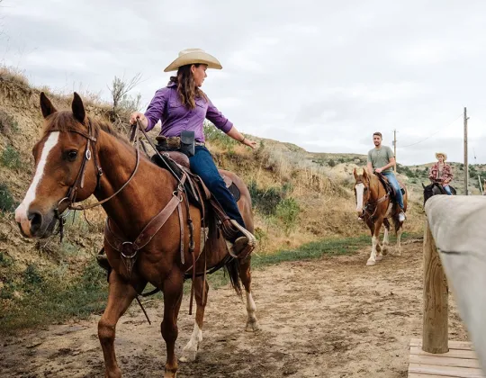 Wrangler leading riders out of the stables