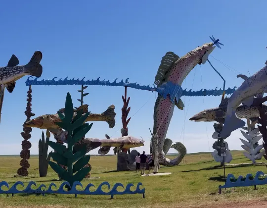 A giant metal sculpture of a fish leaping from a pond