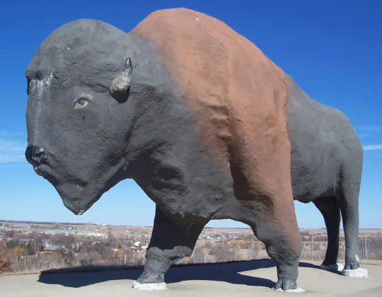 A giant concrete bison statue against the sky