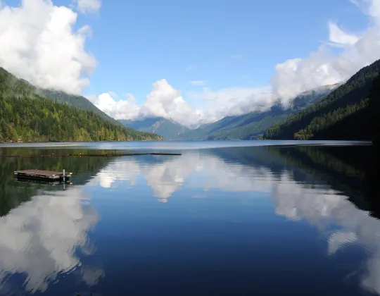 Calm blue water of Lake Crescent below forested mountains