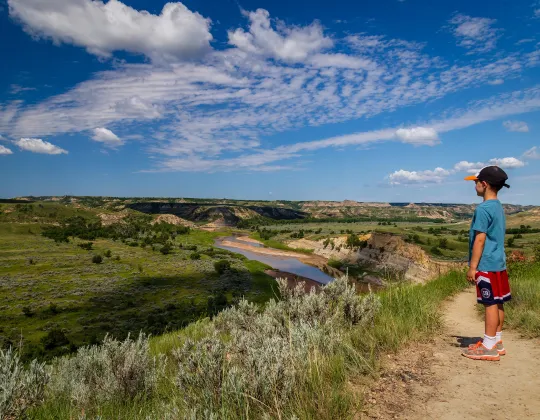 A hiker on a trail above the Little Missouri River in the badlands