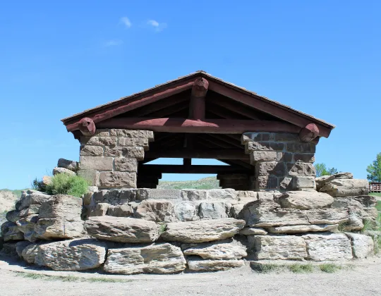 A stone and timber overlook shelter above the badlands