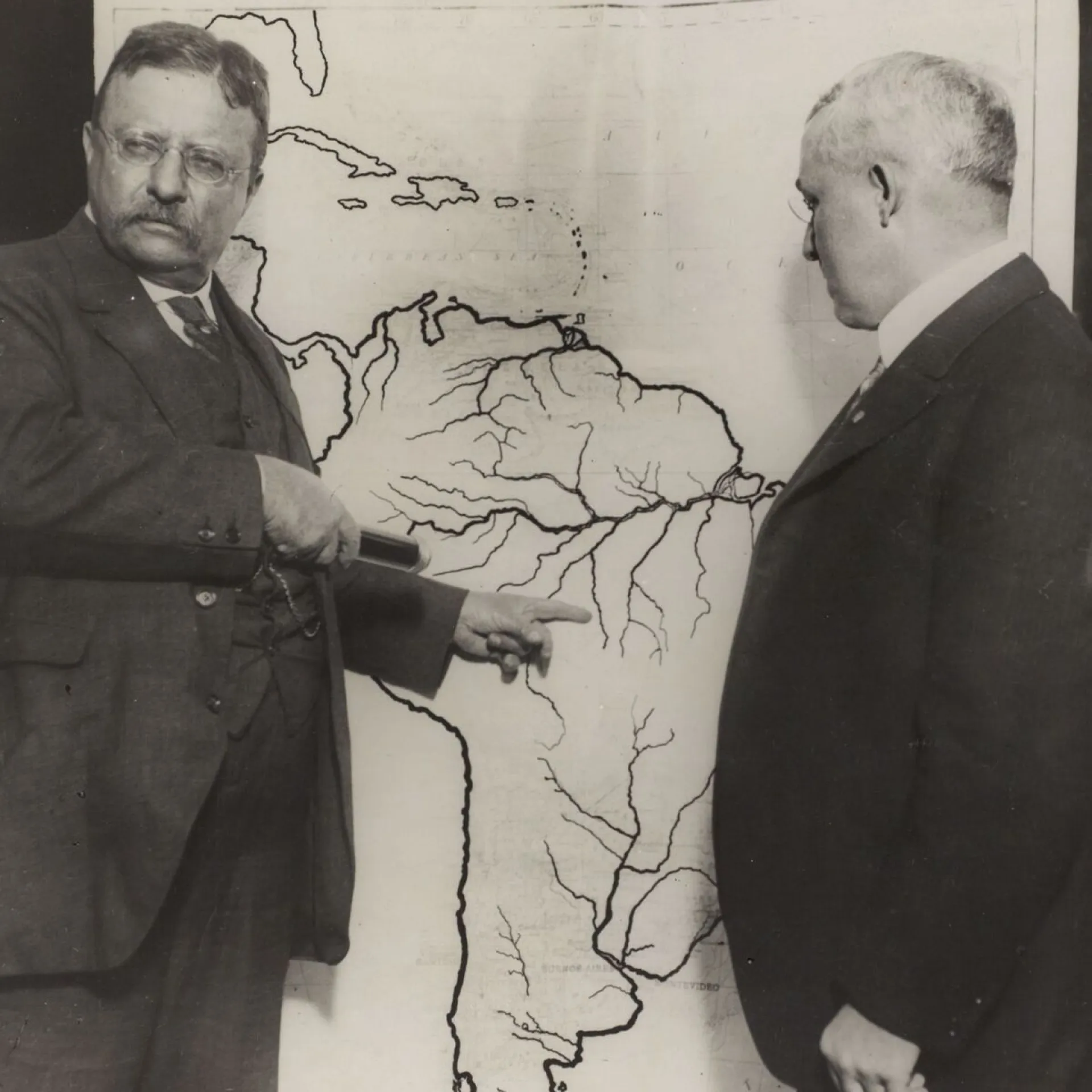 Roosevelt studying a map of South America with an expedition planner